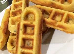 Una foto de Mini waffles de cebolla de rama, tocineta y quesito