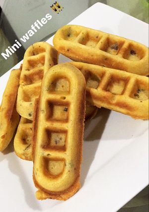 Una foto de Mini waffles de cebolla de rama, tocineta y quesito