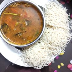 A picture of Idiyaapam with rasam.