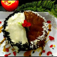A picture of Mango cake topping with chocolate and mango sauce.