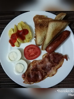 A picture of Bacon, bread and eggs breakfast.