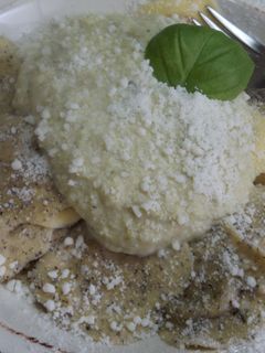 Una foto de Ravioli rellenos de queso y trufa con salsa de brécol