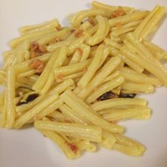 A picture of Pasta with speck (type of cured ham), mushrooms and saffron.