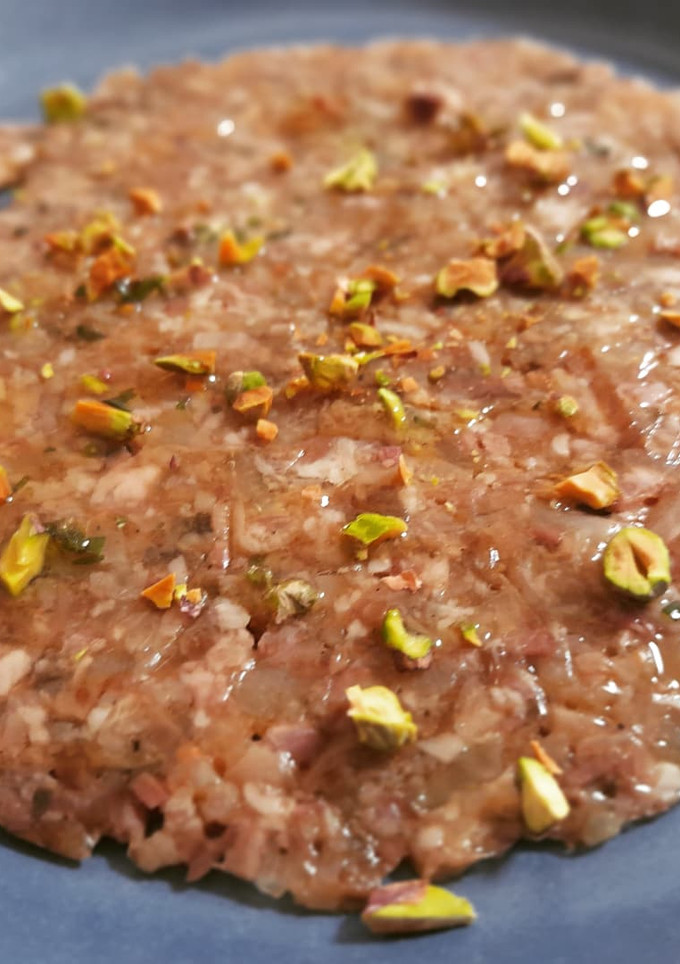 Una foto de Carpaccio de pies de cerdo, ceps y pistachos