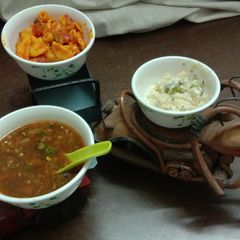 A picture of Penne pasta in red and white sauce with manchow soup.