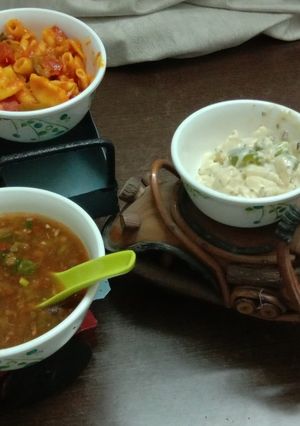 A picture of Penne pasta in red and white sauce with manchow soup.