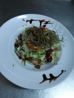 Una foto de Ensalada templada de rulo de queso de cabra y gulas