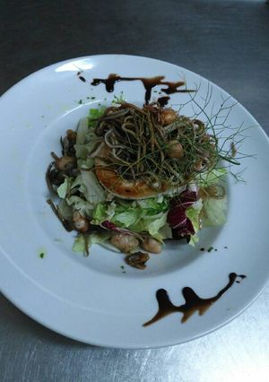 Una foto de Ensalada templada de rulo de queso de cabra y gulas