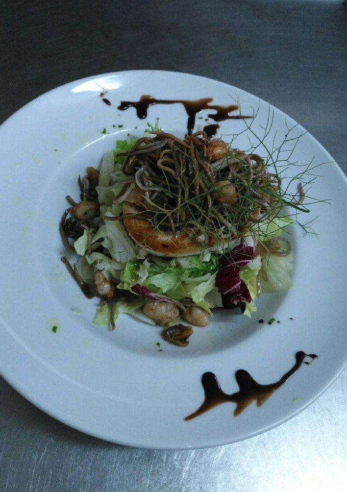 Una foto de Ensalada templada de rulo de queso de cabra y gulas