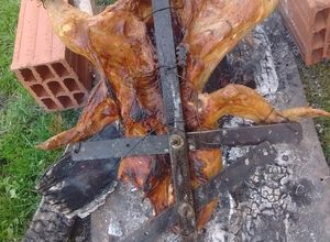 Una foto de Asado a la cruz de pollo y chori de puro cerdo al gancho