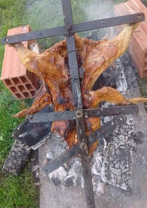 Una foto de Asado a la cruz de pollo y chori de puro cerdo al gancho