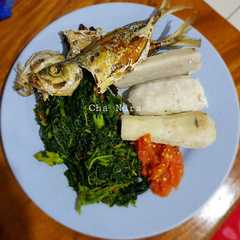 A picture of Ikan goreng tumis daun pepaya keladi rebus sambal mentah.