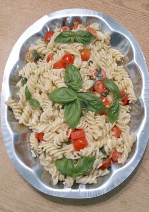 Una foto de Fideos tirabuzones con Cherry y albahaca