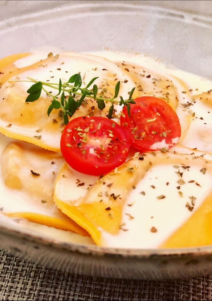 Una foto de Pasta rellena de tomate, mozzarela y berenjena con crema suave de cabrales