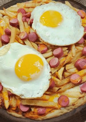 Una foto de 🍕Pizza cochina 🍕😅Pizza con papas fritas, salchichas, cheddar y huevo frito