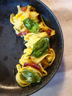 Foto di Tagliatelle alla zucca con pesto montato, pancetta e basilico croccante