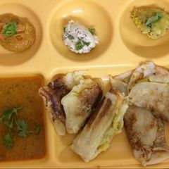 A picture of Mysore masala Dosa with red chutney and coconut chutney.
