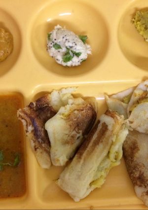 A picture of Mysore masala Dosa with red chutney and coconut chutney.