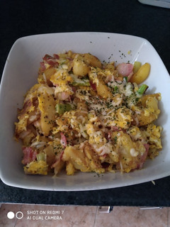 Una foto de Patatas fritas con ajos tiernos bacon y huevo