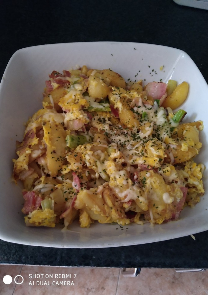 Una foto de Patatas fritas con ajos tiernos bacon y huevo