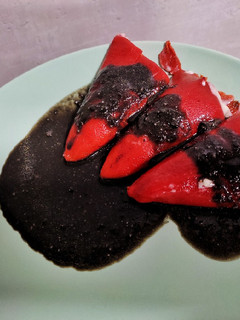 Una foto de Pimientos de piquillo rellenos de chipirón y salsa negra