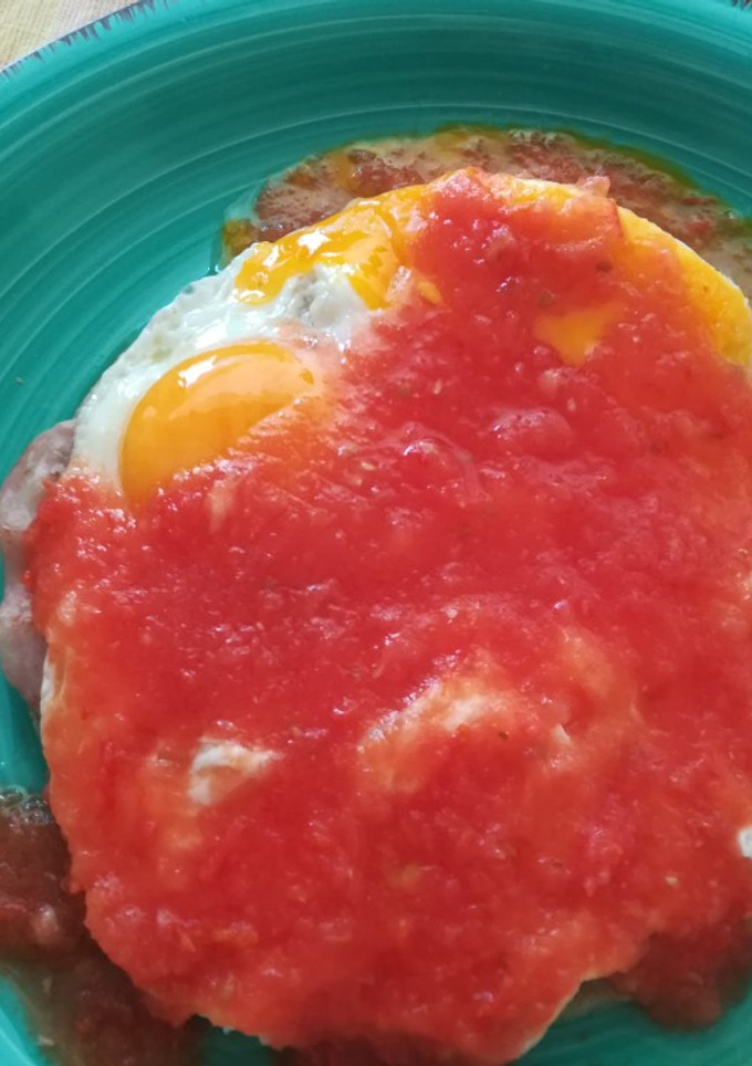 Una foto de Huevos rancheros con jamón y frijoles refritos
