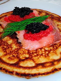 Una foto de Blinis australiano con salmón ahumado y caviar de dos colores