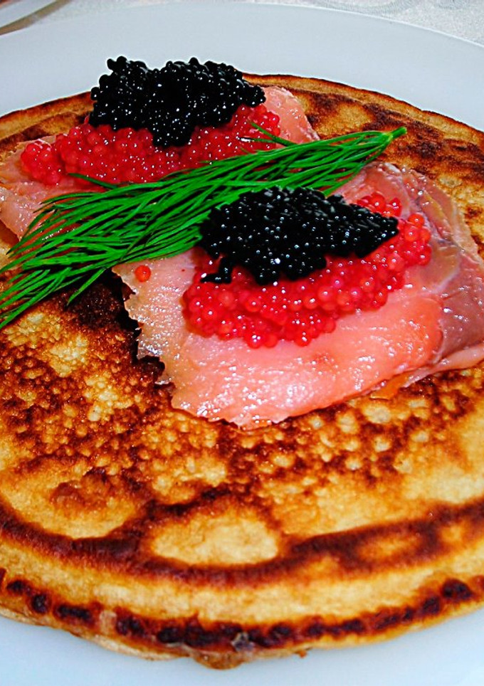 Una foto de Blinis australiano con salmón ahumado y caviar de dos colores