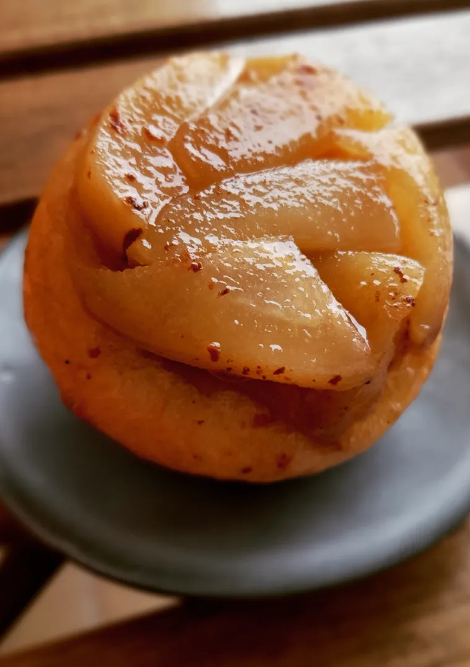 Una foto de Tatin individual de pera con base de rollito de canela de brioche