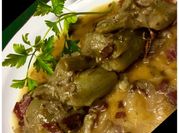 Una foto de alcachofa con jamón y salsa