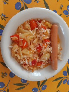 A picture of Hungarian Lecsó with rice and hot-dog.