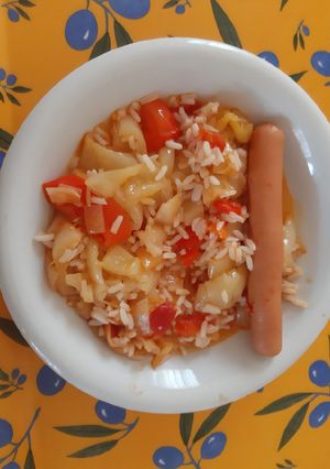 A picture of Hungarian Lecsó with rice and hot-dog.