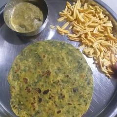 A picture of Methi paratha with green chutney.