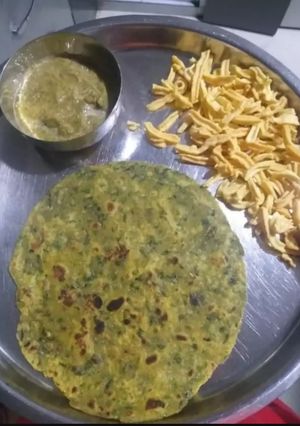 A picture of Methi paratha with green chutney.