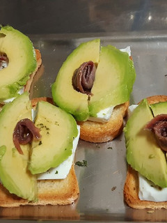 Una foto de Tostas de queso fresco, aguacate y anchoa