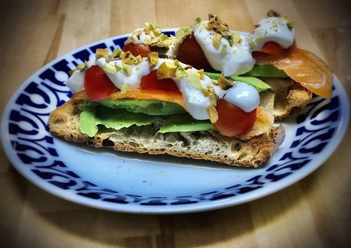 Tosta de aguacate, salmón marinado, tomate, yogur y pistachos