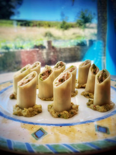 Una foto de Canelones fríos de bonito del norte sobre cama de guacamole