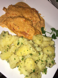 Una foto de Pechuga de pollo con crema, acompañada de papas salteadas