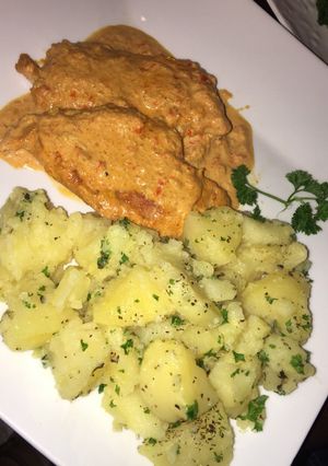 Una foto de Pechuga de pollo con crema, acompañada de papas salteadas