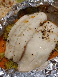 Una foto de Pescado empapelado con brócoli y zanahoria en freidora de aire