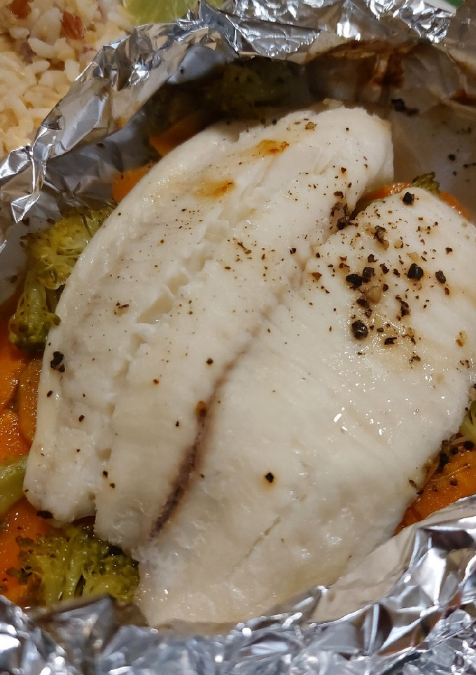 Una foto de Pescado empapelado con brócoli y zanahoria en freidora de aire