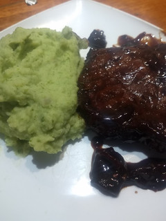 Una foto de Chuletas al vino, anchoas, ciruela y hongos con puré verde