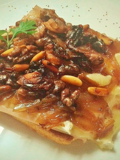 Una foto de Tostas de pechuga de pavo y queso brie con cebolla, nueces y piñones caramelizados