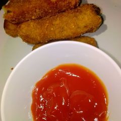 A picture of Potato croquettes with ketchup.