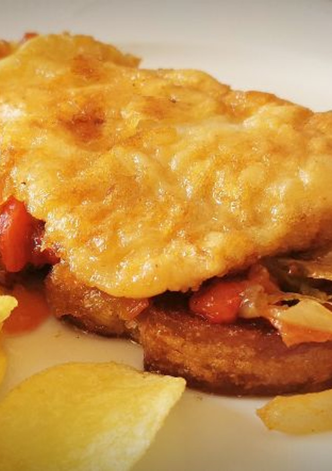 Una foto de Tostada de Merluza rebozada con Piperrada