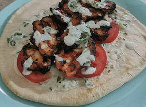 Una foto de Pan pita (gyros) con pollo y aderezo
