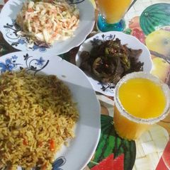 A picture of Small vegetable rice with grilled meat souce da mango juice.