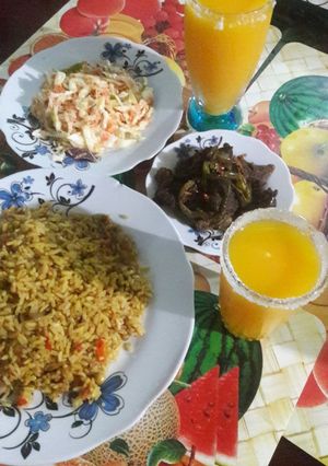 A picture of Small vegetable rice with grilled meat souce da mango juice.