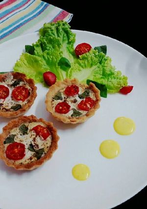 A picture of Tomato basil tarts with creamy saffron sauce.