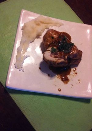 Una foto de Pechuga rellena con jamón, quesos y cebolla morada con crema y puré